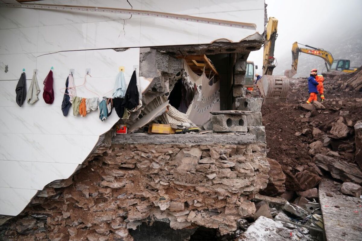 Rescue workers search for survivors near a damaged house after a landslide hit Zhenxiong county in Zhaotong  / STRINGER