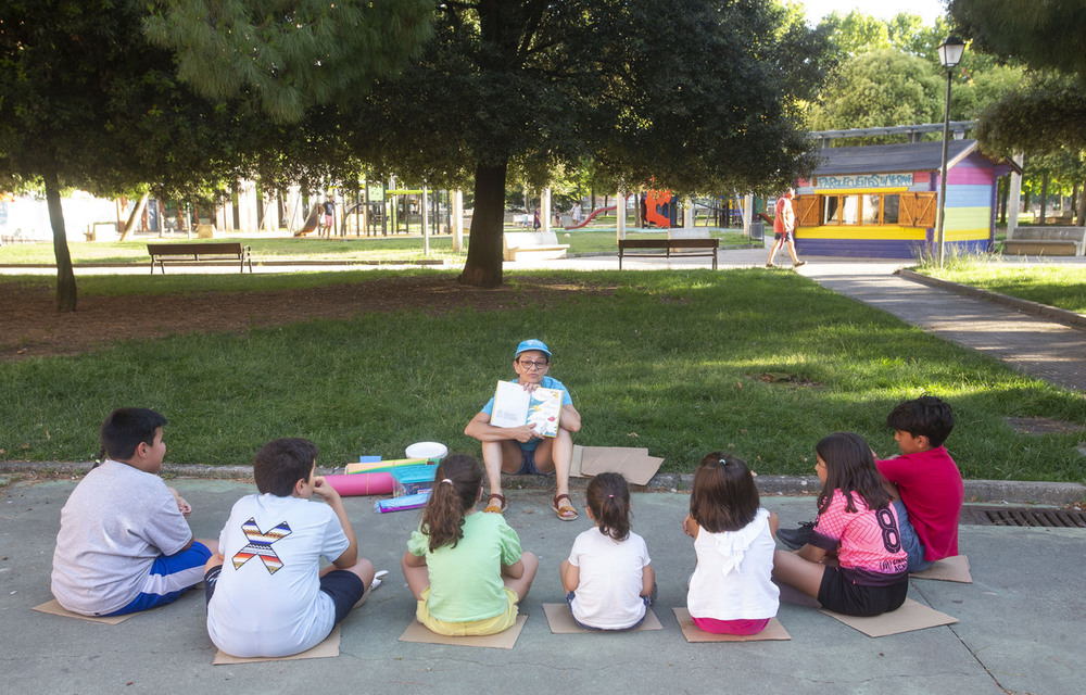 La monitora de verano de la avenida de los Vacceos, Elena Iglesias, explica los juegos relacionados con la lectura que van a realizar a los más pequeños.